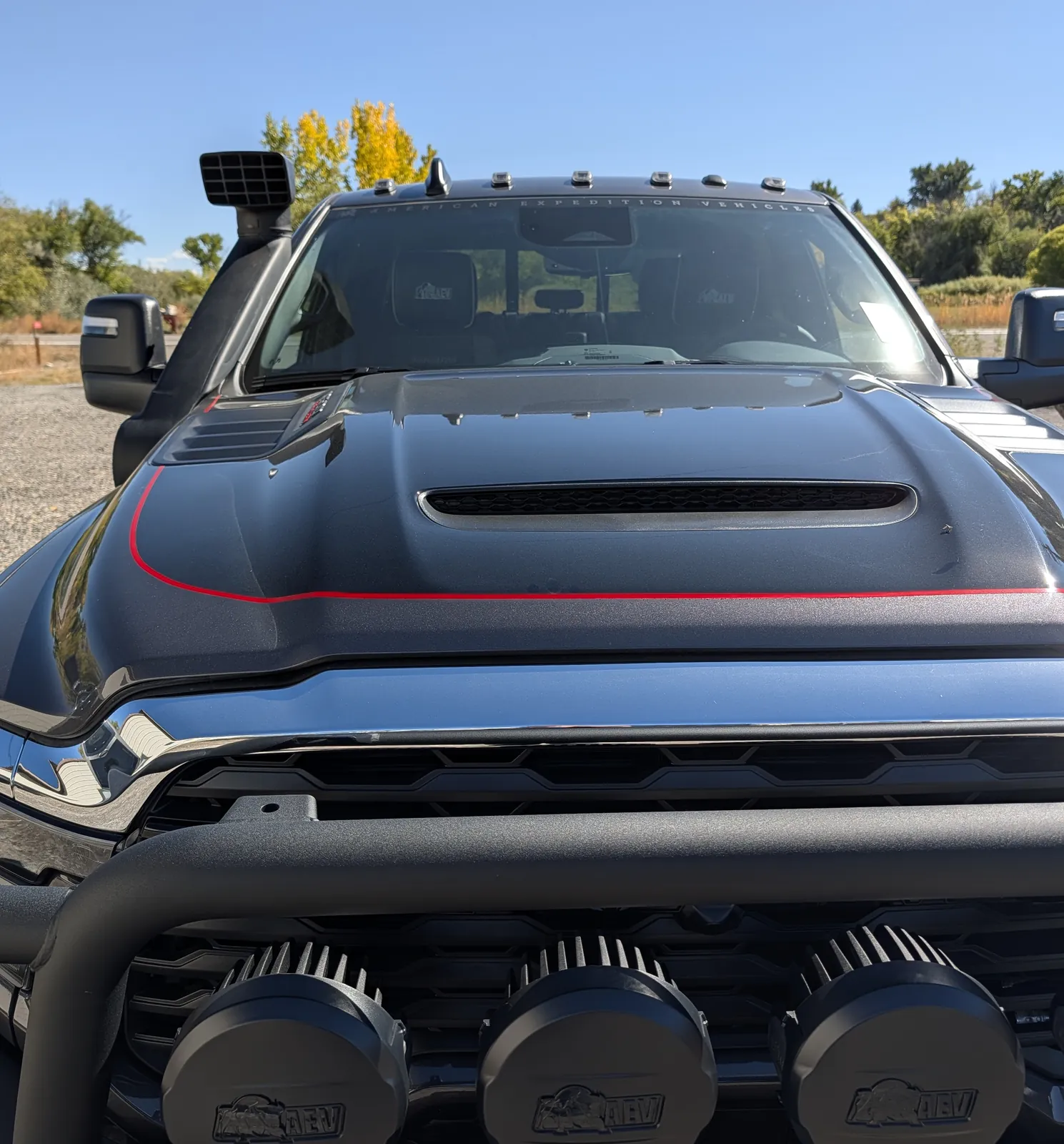 Ram Sport Hood with black paint and red accent, AEV lights below
